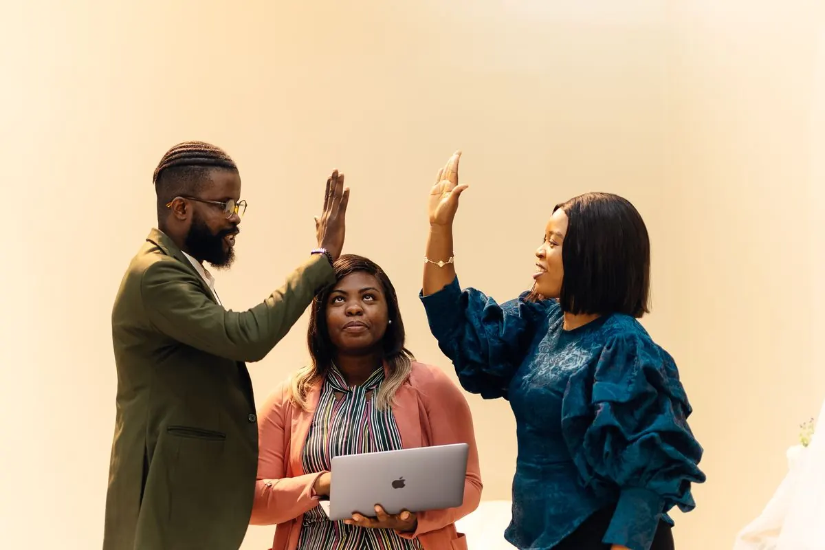 Colleagues celebrating with a high five during a workplace meeting